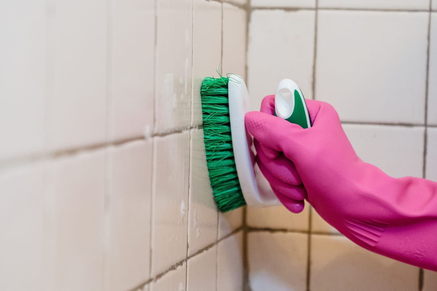 Grout being scrubbed clean on a bathroom tile wall in the Santa Cruz area